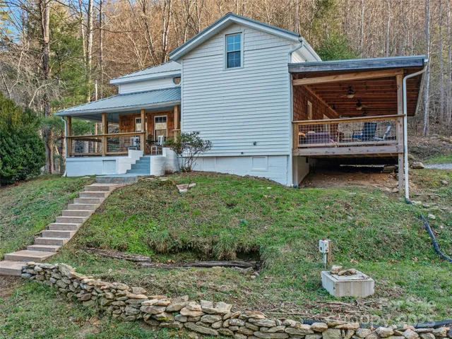 a porch with a table chairs and wooden fence