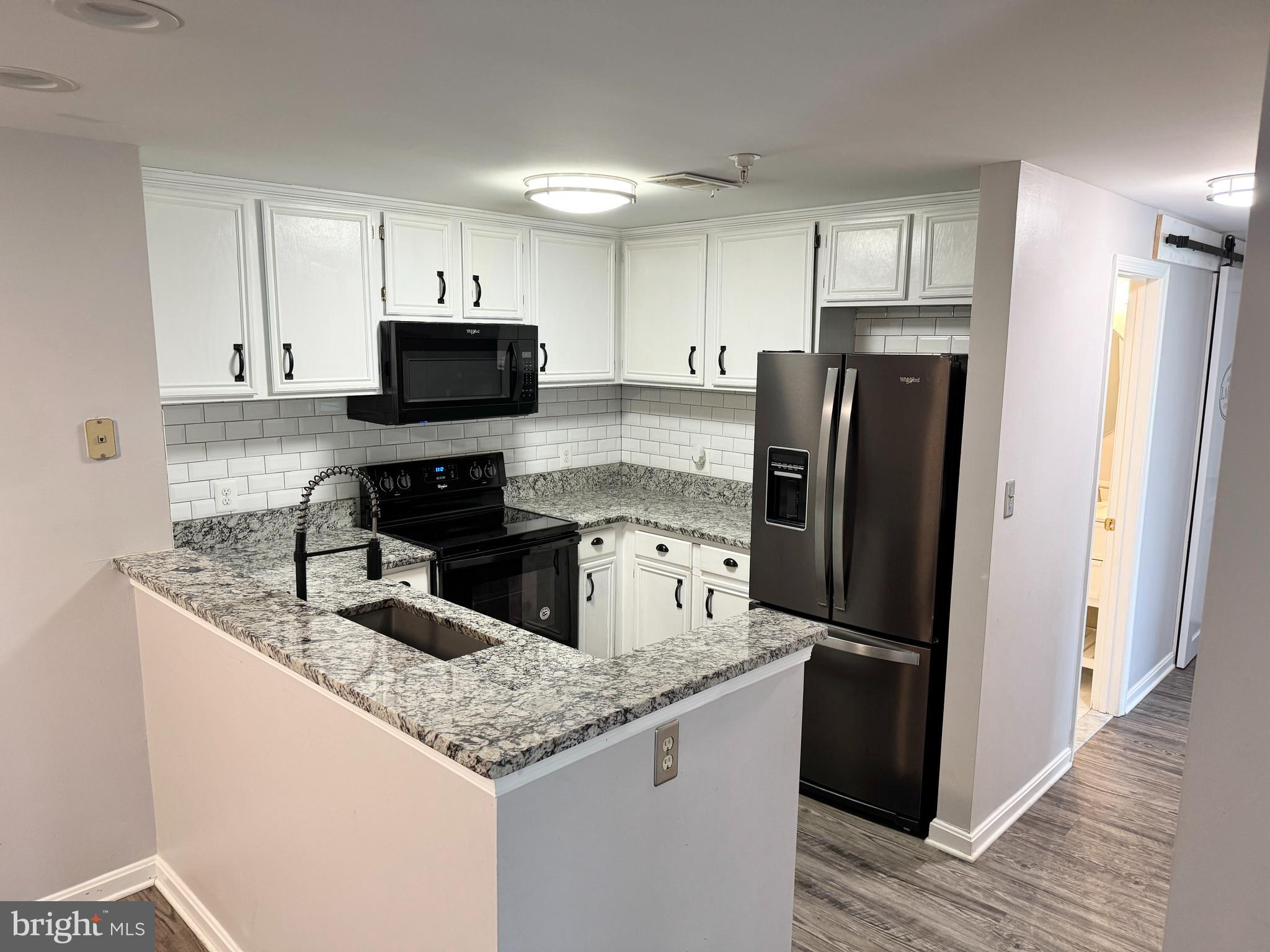 202 Dover Place, Unit 2 Stafford, VA 22556 - Photo 2 of 22 a kitchen with granite countertop a refrigerator a sink a stove a microwave and island