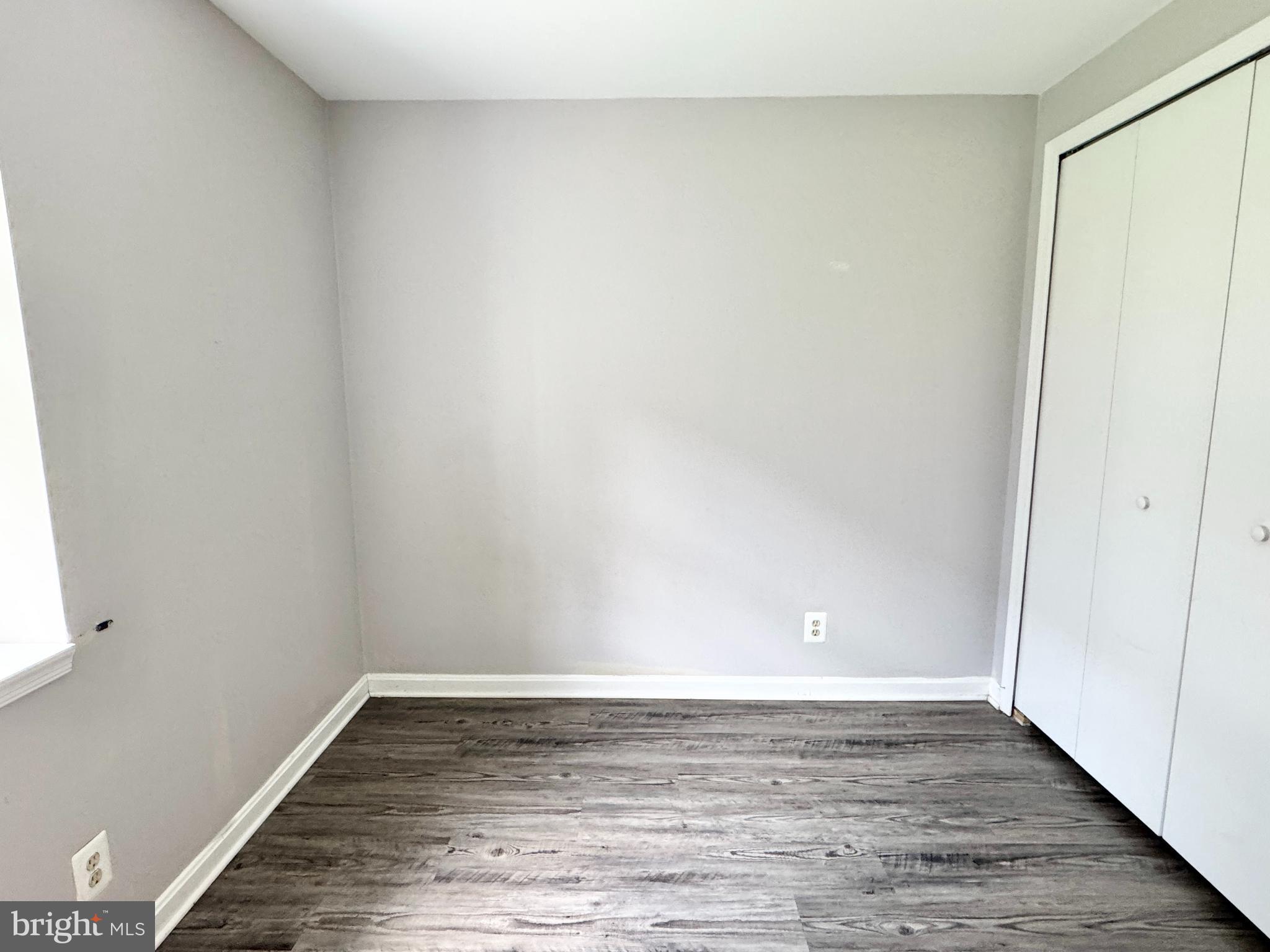 202 Dover Place, Unit 2 Stafford, VA 22556 - Photo 21 of 22 a view of an empty room with wooden floor and a window