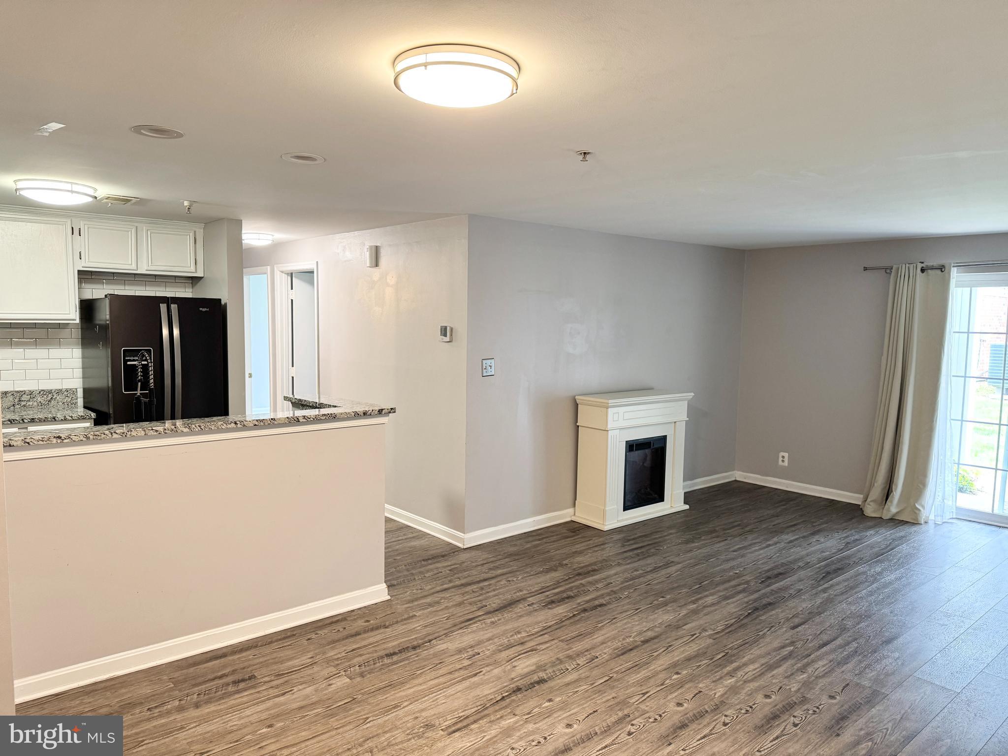 202 Dover Place, Unit 2 Stafford, VA 22556 - Photo 5 of 22 an empty room with wooden floor and fireplace