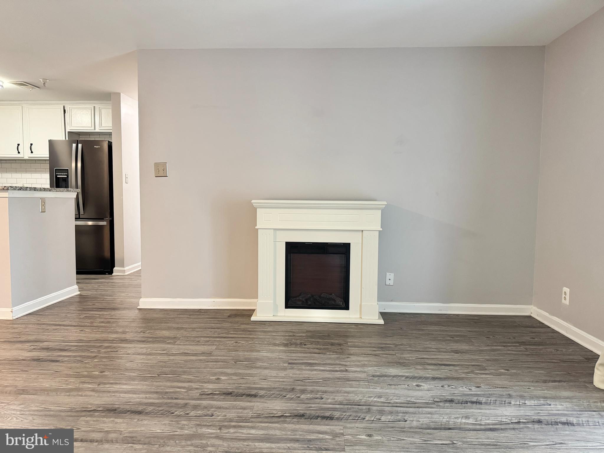 202 Dover Place, Unit 2 Stafford, VA 22556 - Photo 6 of 22 a view of an empty room with wooden floor and a fireplace