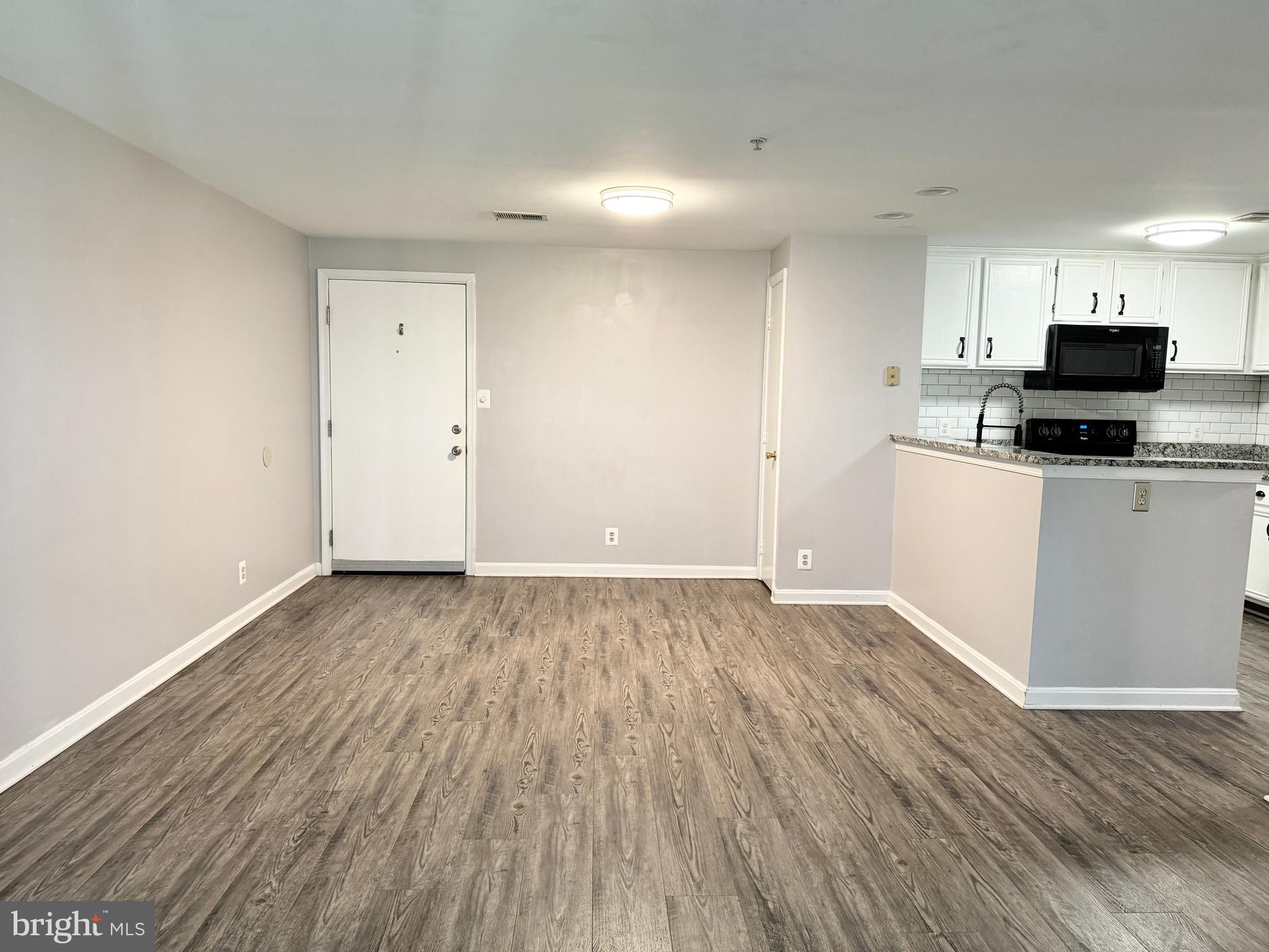 202 Dover Place, Unit 2 Stafford, VA 22556 - Photo 7 of 22 wooden floor in an empty room with a kitchen
