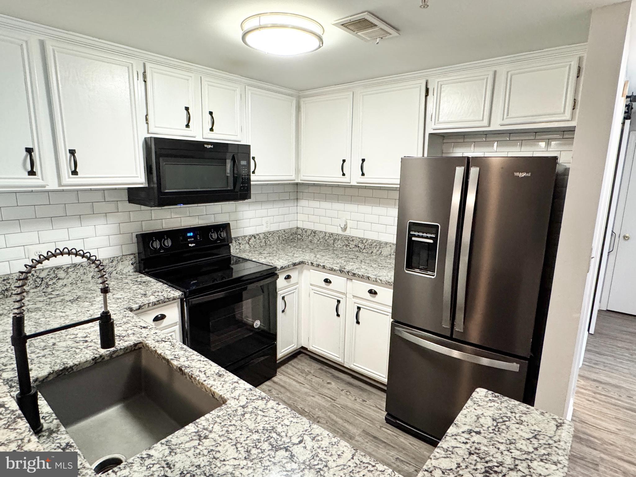 202 Dover Place, Unit 2 Stafford, VA 22556 - Photo 9 of 22 a kitchen with a refrigerator stove and white cabinets