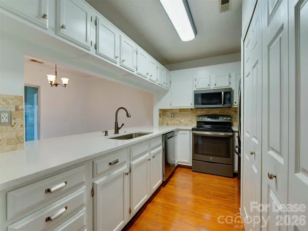 a kitchen with stainless steel appliances a sink stove and cabinets