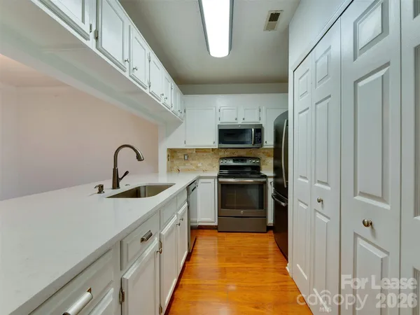 a kitchen with stainless steel appliances a refrigerator sink and stove