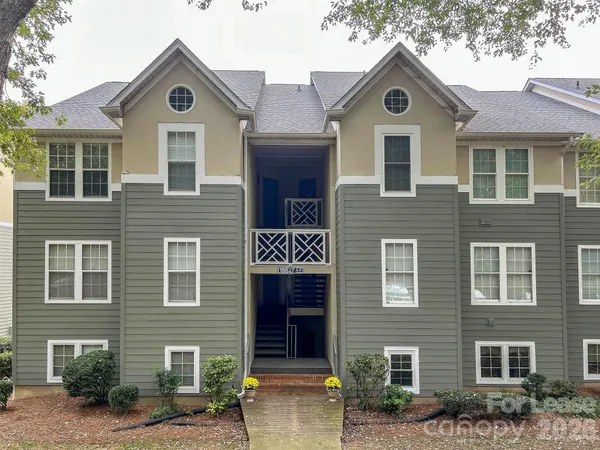 a front view of a house with yard and parking space