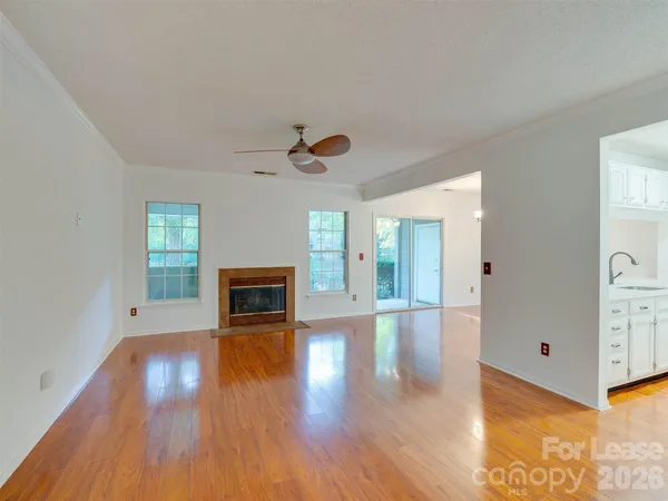 a view of a livingroom with wooden floor a fireplace and window