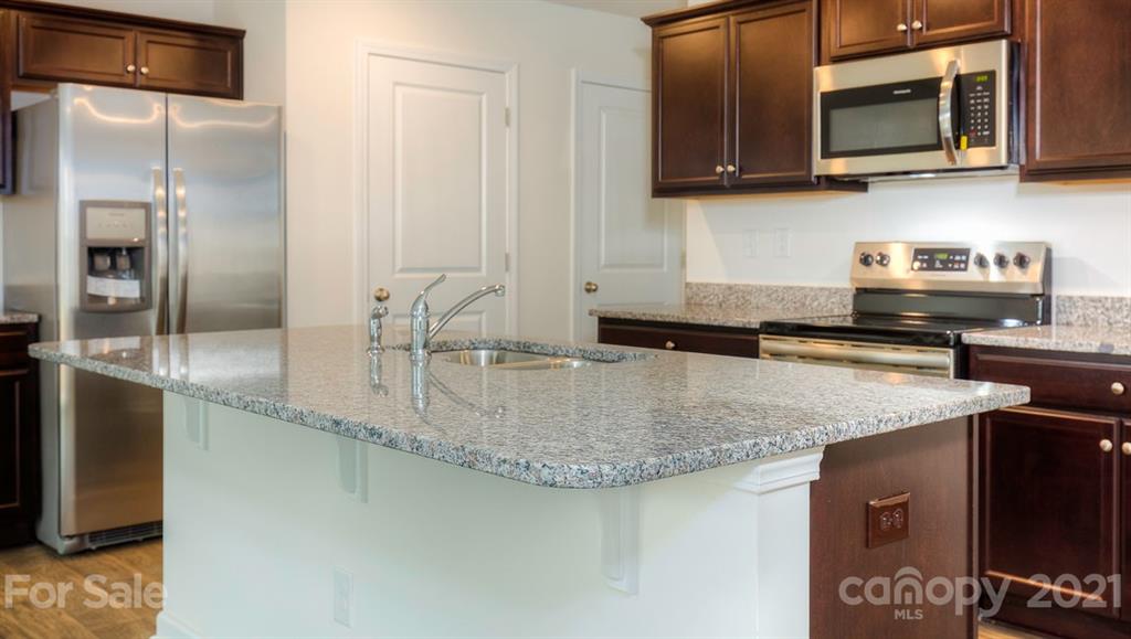 348 Gaines Road Clover, SC 29710 - Photo 21 of 48 a kitchen with stainless steel appliances granite countertop a sink a stove and microwave