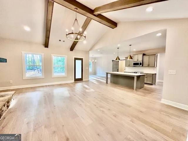 a view of a kitchen with kitchen island a sink wooden floor and a living room view