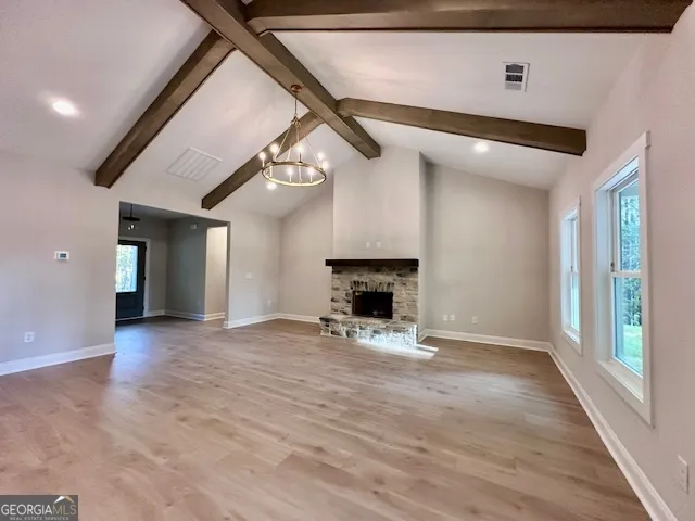 a view of an empty room with a fireplace and a window