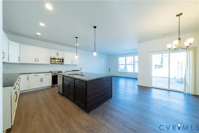 a large kitchen with stainless steel appliances kitchen island a cabinets and wooden floor