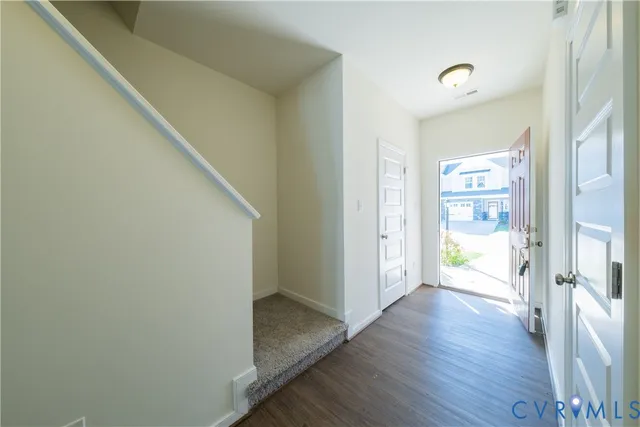 a view of a hallway with wooden floor and a ceiling fan