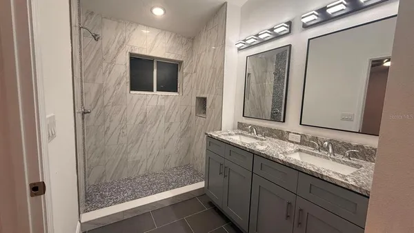 a bathroom with a granite countertop sink mirror and double