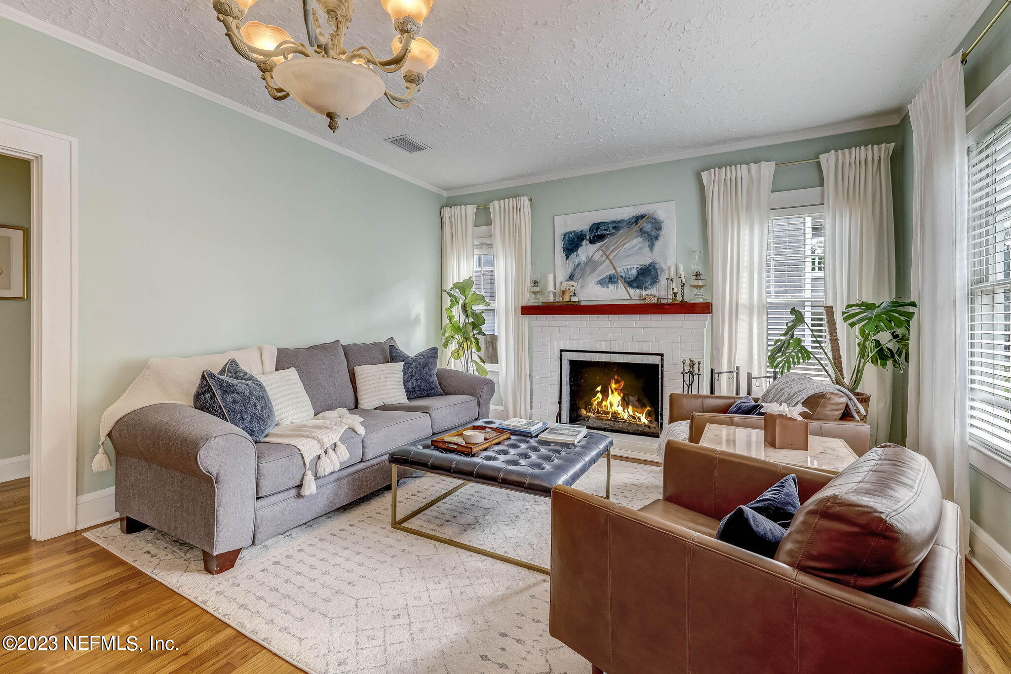 1515 Mayfair Road Jacksonville, FL 32207 - Photo 12 of 52 a living room with furniture a chandelier and a fireplace