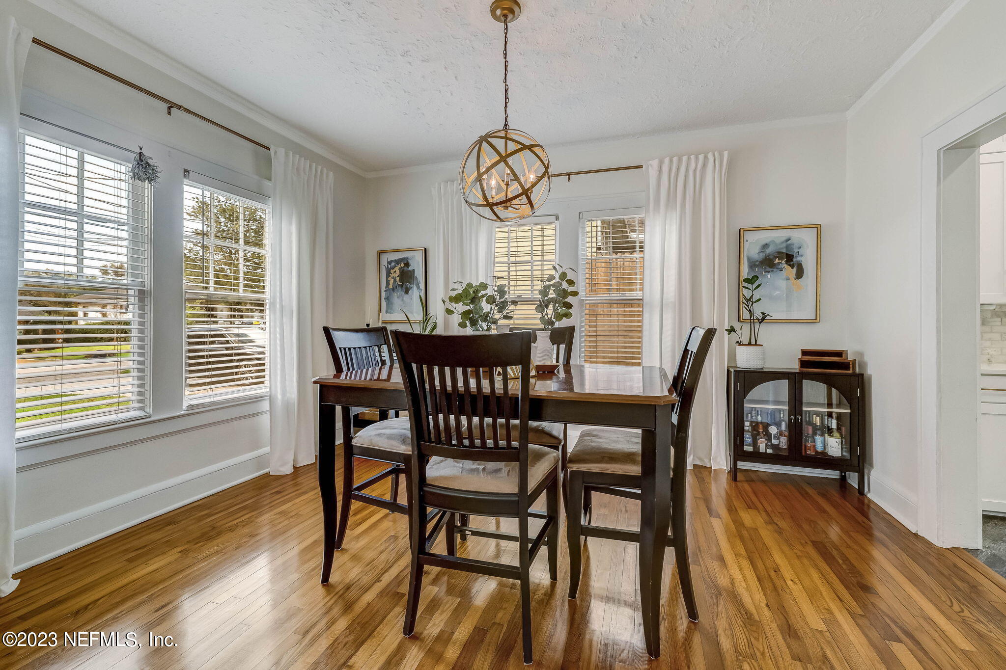 1515 Mayfair Road Jacksonville, FL 32207 - Photo 15 of 52 a dining room with wooden floor a chandelier a wooden table and chairs
