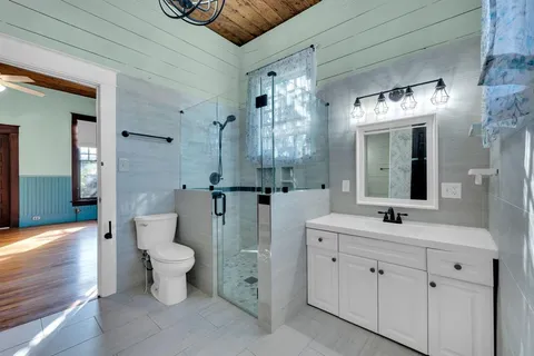 a spacious bathroom with a double vanity sink toilet mirror and bathtub