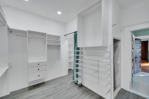 a view of an empty room with wooden floor and windows