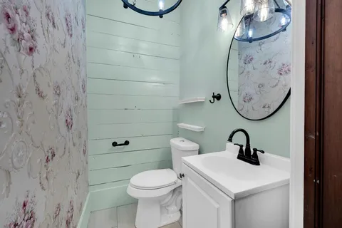 a bathroom with a toilet sink and mirror