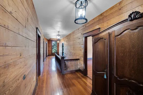 a view of a hallway with wooden floor and staircase