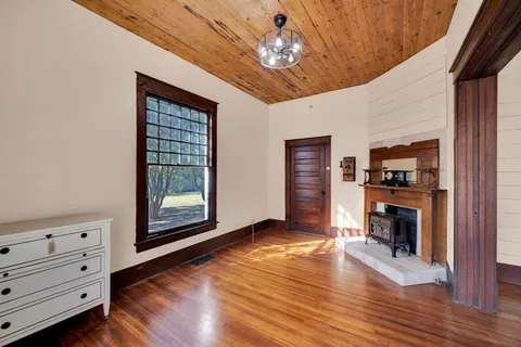 a view of an empty room with a window and fireplace
