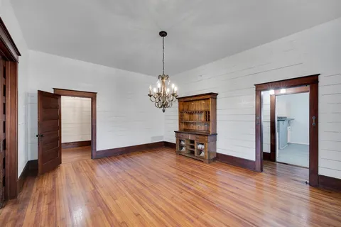 a view of a livingroom with wooden floor and a ceiling fan