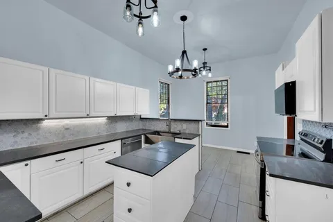 a kitchen with stainless steel appliances granite countertop a sink a stove and cabinets