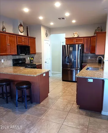 a kitchen with stainless steel appliances granite countertop a stove a sink and a refrigerator