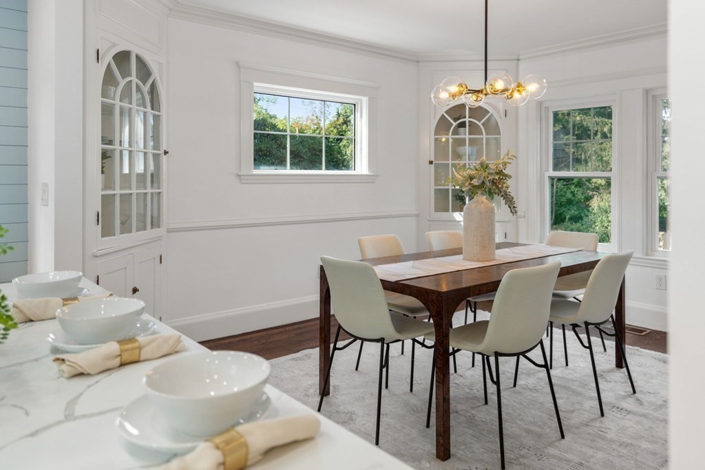 4 Clement Avenue Boston, MA 02132 - Photo 12 of 39 a dining room with furniture a chandelier and wooden floor