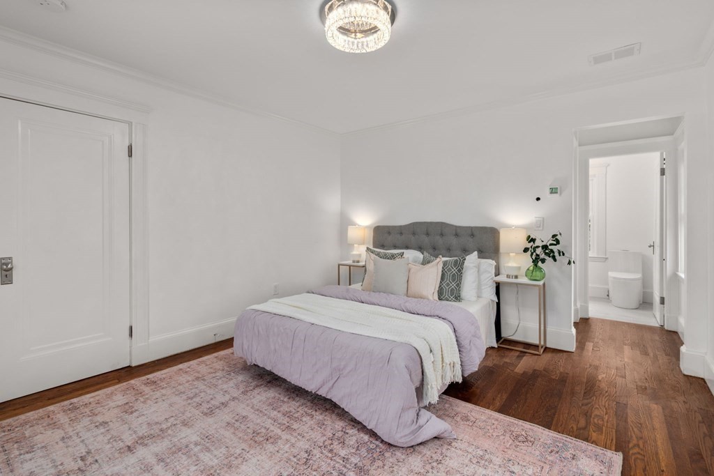 4 Clement Avenue Boston, MA 02132 - Photo 19 of 39 a bedroom with a bed and a chandelier