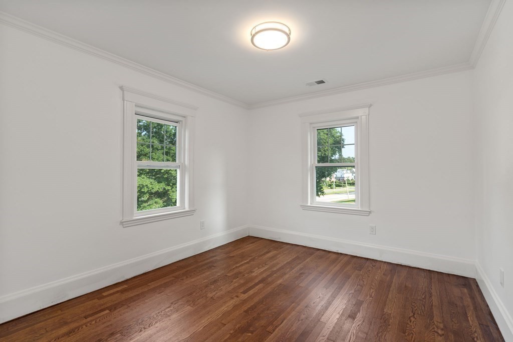 4 Clement Avenue Boston, MA 02132 - Photo 21 of 39 an empty room with wooden floor and windows