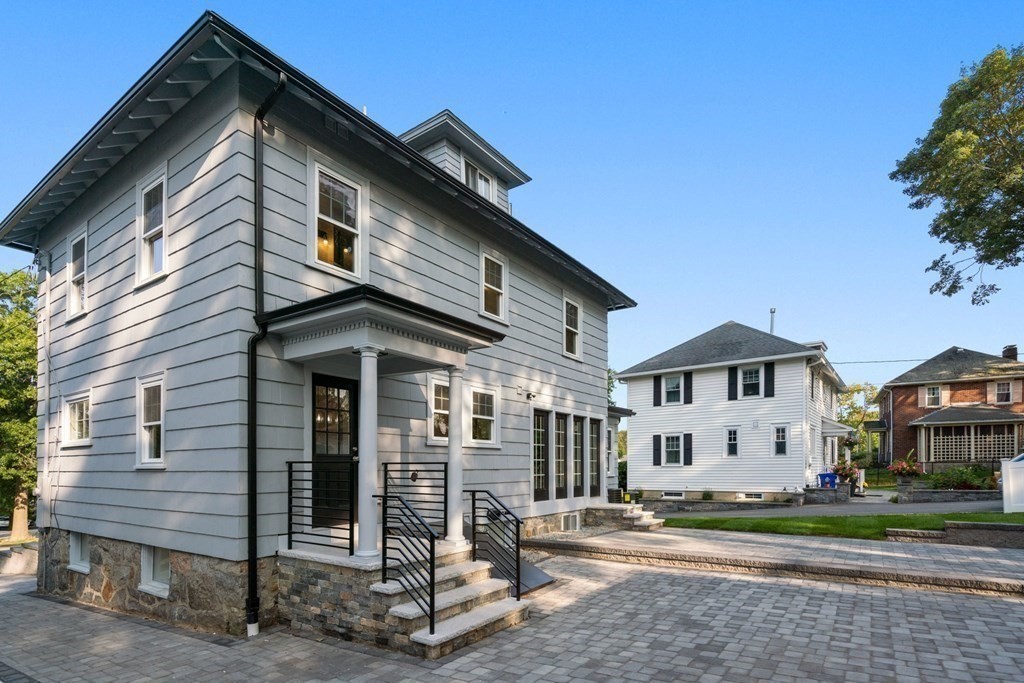 4 Clement Avenue Boston, MA 02132 - Photo 28 of 39 a view of a white house with large windows and a table and chairs