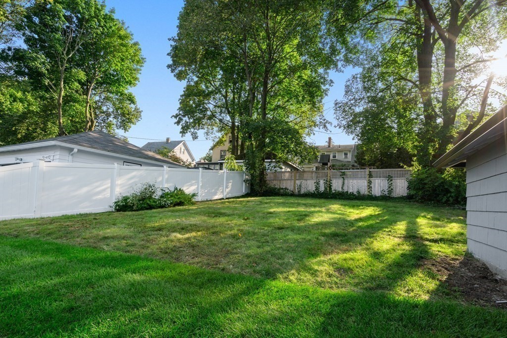 4 Clement Avenue Boston, MA 02132 - Photo 30 of 39 a backyard of a house with plants and large trees