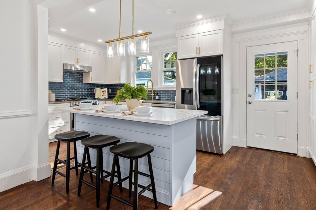 4 Clement Avenue Boston, MA 02132 - Photo 9 of 39 a kitchen with granite countertop a table chairs sink and cabinets