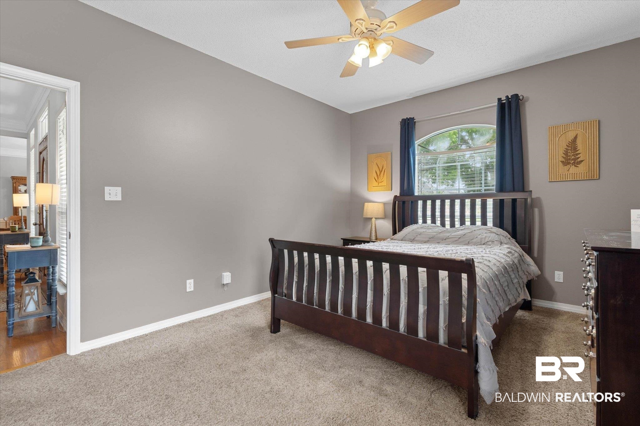 3170 Scott Dairy Loop Road West Mobile, AL 36695 - Photo 11 of 24 Carpeted room featuring a ceiling fan with integrated lighting, an arched window with blinds and blue drapery, and a neutral wall color