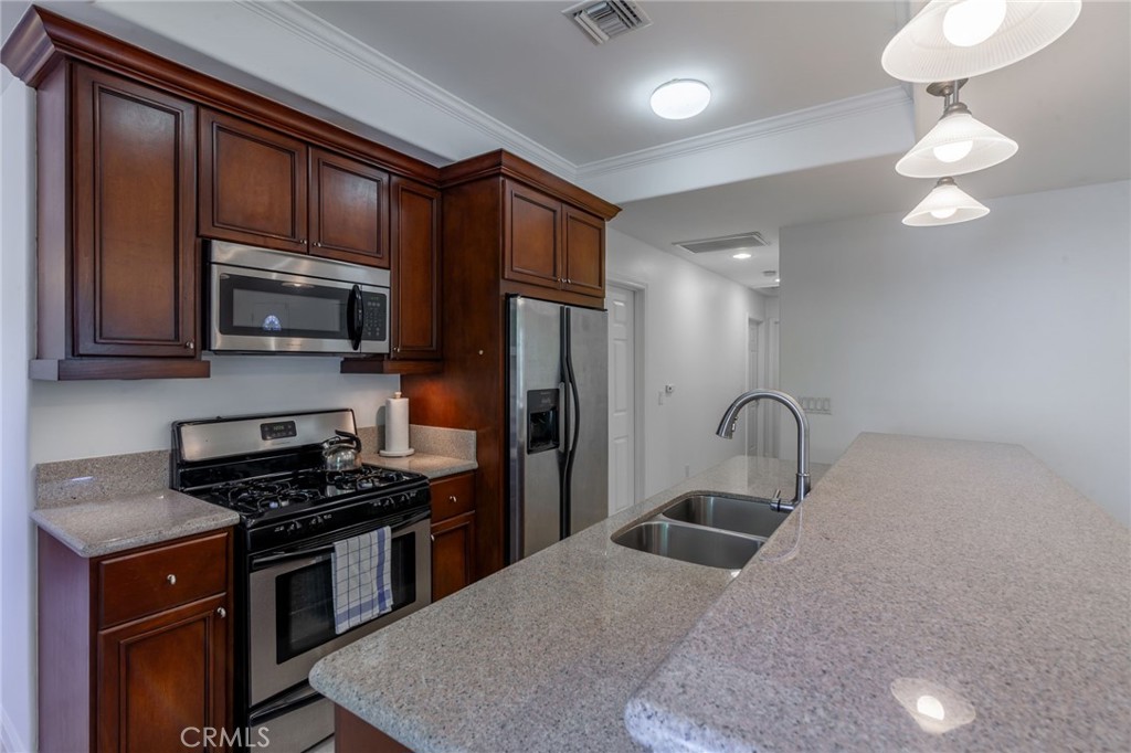 10424 Big Tujunga Canyon Road Tujunga, CA 91042 - Photo 17 of 57 a kitchen with stainless steel appliances a stove a sink a microwave and cabinets