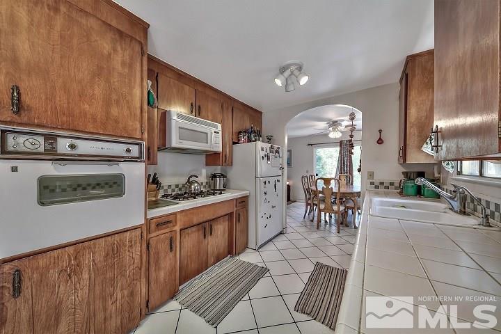 252 North Benjamin Drive Stateline, NV 89449 - Photo 11 of 19 a kitchen with stainless steel appliances kitchen island granite countertop a refrigerator a stove a sink a dining table and chairs with wooden floor