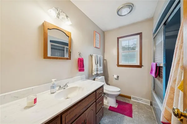 a bathroom with a sink vanity mirror and toilet