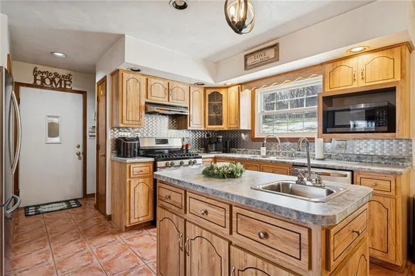 a kitchen with stainless steel appliances granite countertop a sink stove and cabinets