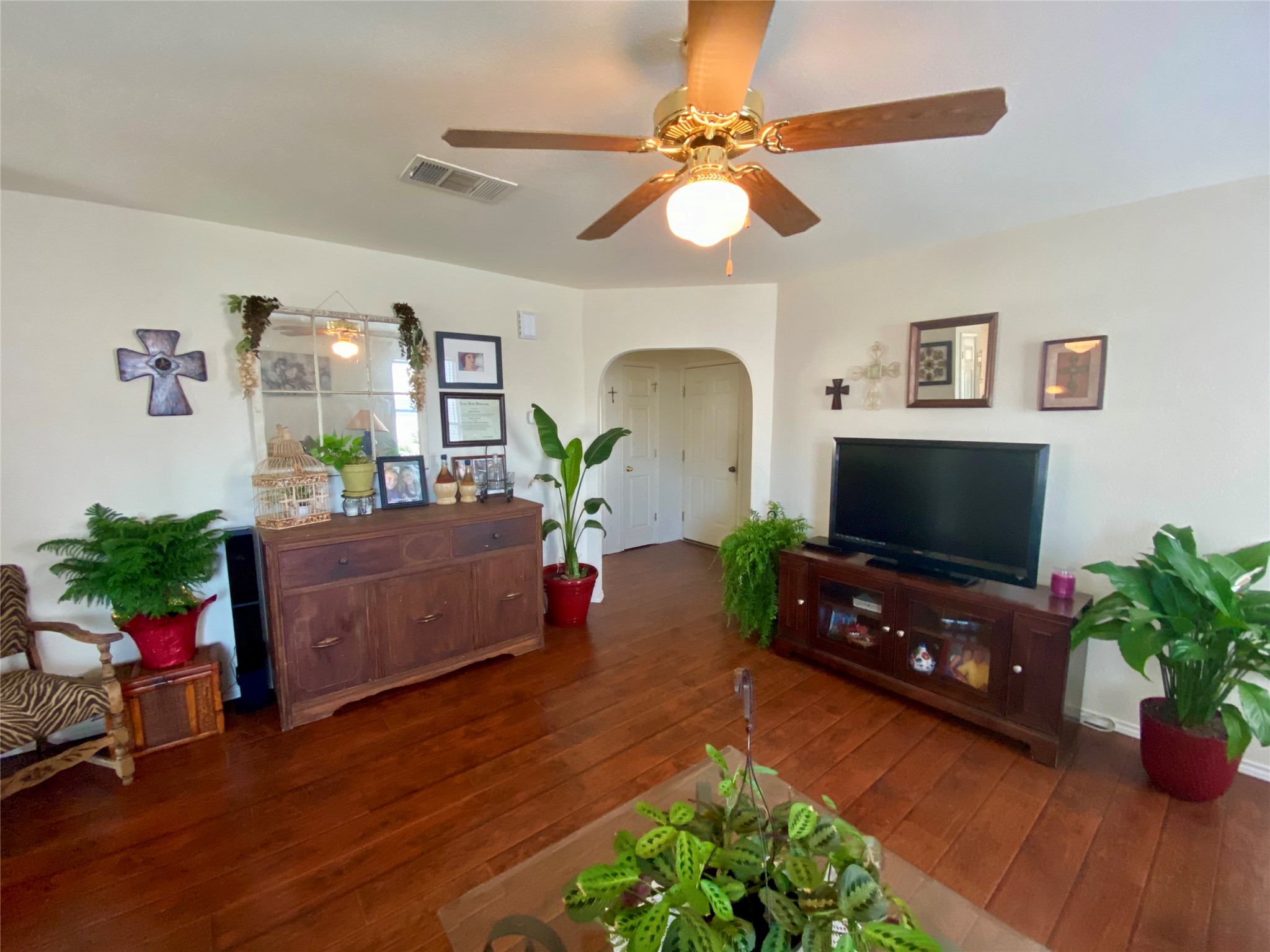 14420 Cummins Way Manor, TX 78653 - Photo 17 of 20 Living space featuring wood-finish flooring, a ceiling fan with integrated lighting, and an arched doorway