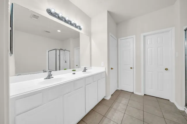 a bathroom with a double vanity sink and a mirror