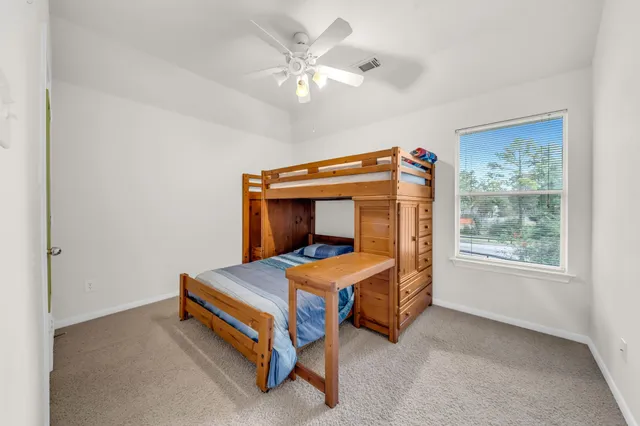 a bedroom with a bed and a ceiling fan
