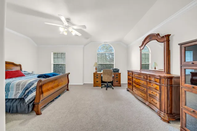 a bedroom with furniture and a large window