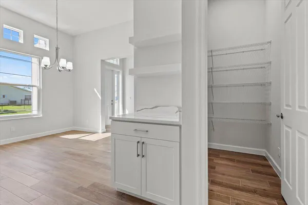 a view of empty room with wooden floor and window