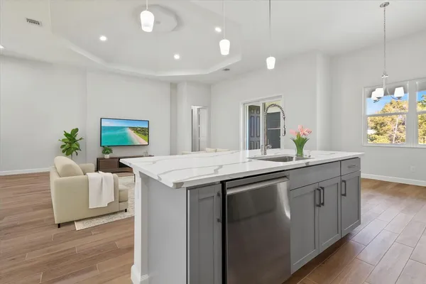 a kitchen with granite countertop a sink and a stove with wooden floor