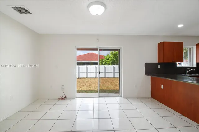 a view of kitchen with stainless steel appliances granite countertop a refrigerator and a sink