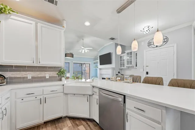 a kitchen with stainless steel appliances a table chairs and a refrigerator