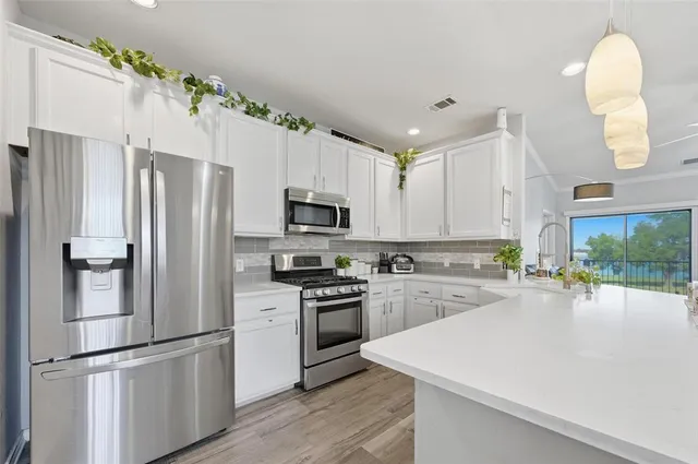 a kitchen with cabinets a sink and dishwasher with wooden floor
