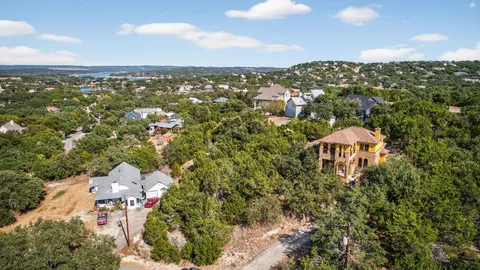 an aerial view of a house with a yard and mountain view in back