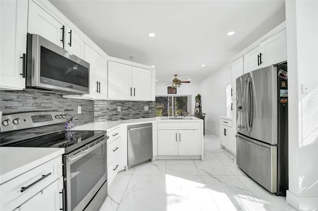 a kitchen with cabinets stainless steel appliances and a counter space