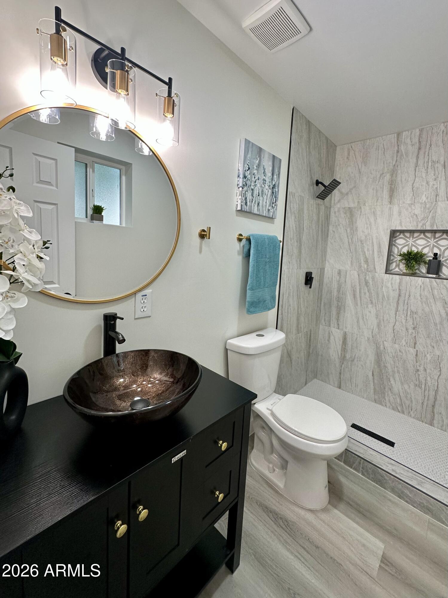 5236 South 19th Avenue Phoenix, AZ 85041 - Photo 28 of 47 a bathroom with a toilet a sink and mirror